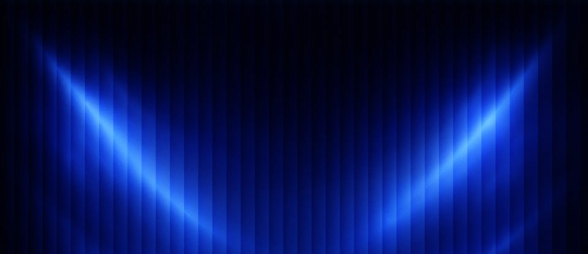 Blue light beams sweeping across a dark stage curtain
